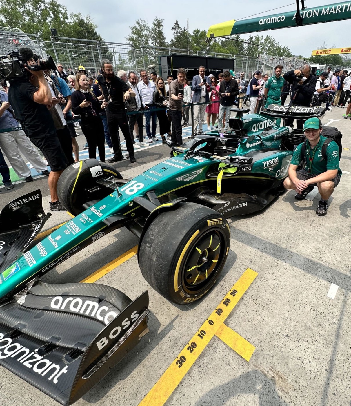 Eli Shamis on the starting grid beside the Aston Martin Aramco Formula One car during his internship.